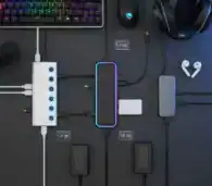 USB hub with multiple ports connected to gaming accessories and devices on a dark desk.