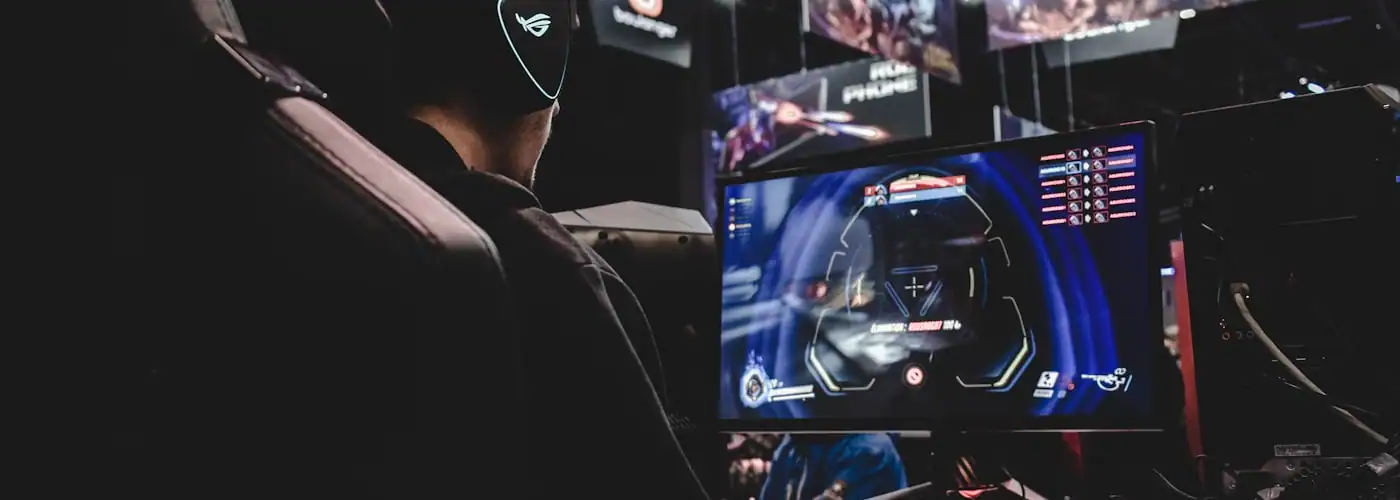 Gaming setup with RGB keyboard and monitor displaying colorful game